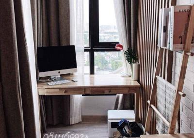 Cozy and well-lit home office space with a large window and wooden furniture