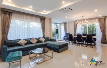 Spacious open-plan living and dining room with modern furniture and natural light