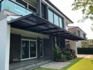 Modern two-story house with glass windows and an extended canopy