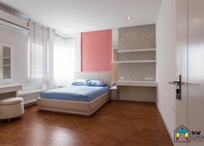 Spacious bedroom with modern design, hardwood floors and ample natural light