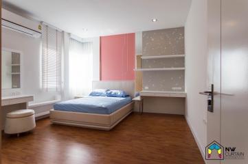 Spacious bedroom with modern design, hardwood floors and ample natural light