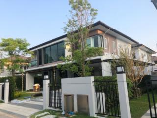 Modern two-story house with large windows and a neat front yard