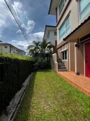 Exterior view of a modern two-story house with a lush garden