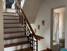 Elegant wooden staircase with access to upper level in a well-lit home interior