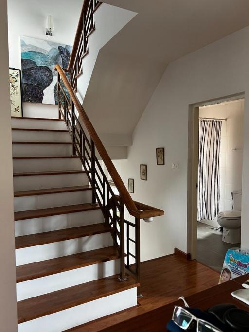 Elegant wooden staircase with access to upper level in a well-lit home interior