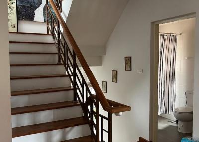 Elegant wooden staircase with access to upper level in a well-lit home interior