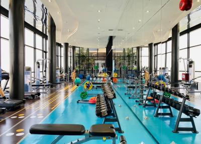 Modern gym facility with exercise equipment and large windows