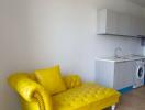 Bright studio apartment with yellow sofa and integrated kitchenette