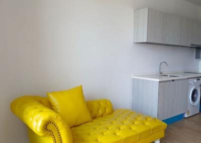 Bright studio apartment with yellow sofa and integrated kitchenette