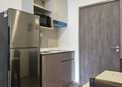 Modern kitchen with stainless steel appliances and wooden door