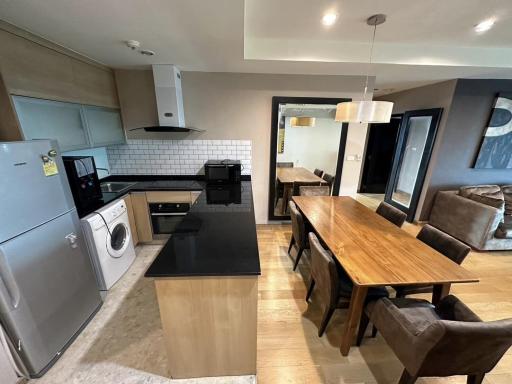 Modern kitchen with stainless steel appliances, wooden dining table, and open plan layout