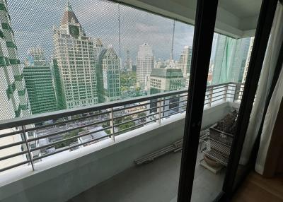 City view from high-rise apartment balcony with glass railing