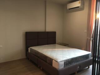 Spacious bedroom with large bed and modern air conditioning unit