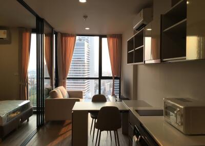 Modern living room with city view, natural light, and open kitchen