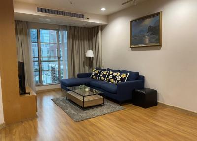 Modern living room with a blue sofa, wooden flooring, and natural light