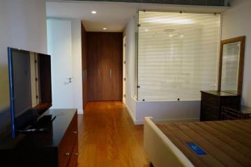 Modern bedroom with wooden flooring and ample natural light