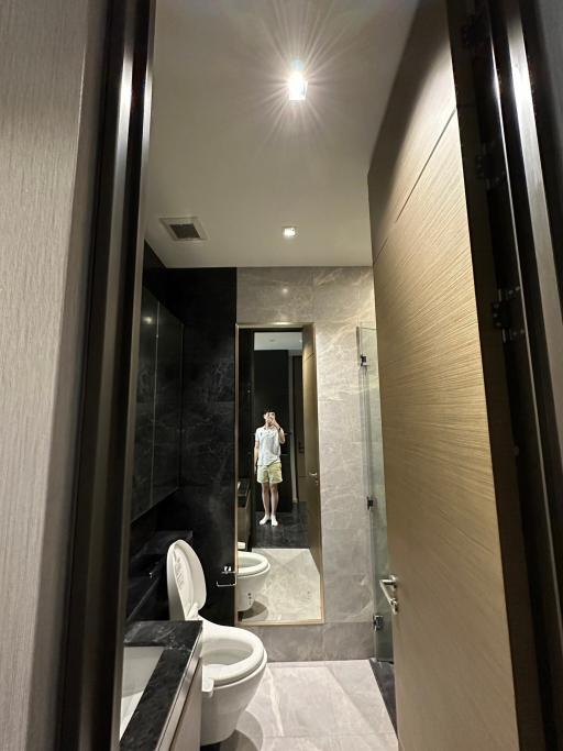 Modern bathroom interior with reflected person in the mirror