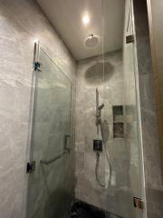 Modern bathroom with glass shower enclosure and marble tiles