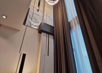 High-ceiling living room interior with modern lighting and elegant design