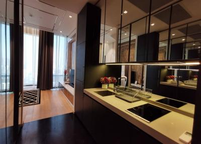 Modern kitchen with stainless steel appliances, black cabinetry, and glass accents