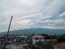 Panoramic view of the surrounding area from a building, featuring mountains in the distance and a construction site