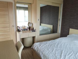 Cozy bedroom interior with large bed and mirrored wardrobe