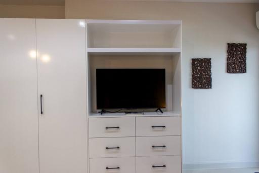 Modern living room interior with a flat-screen TV and white storage cabinets