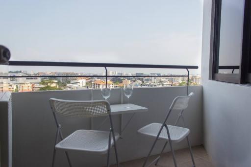 Modern balcony with a view of the city, featuring a small table and two chairs