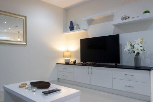 Modern living room with mounted television and white cabinets
