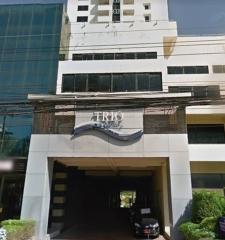 Exterior view of a modern apartment building facade with a visible sign that says 