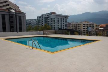 Rooftop pool with a city and mountain view