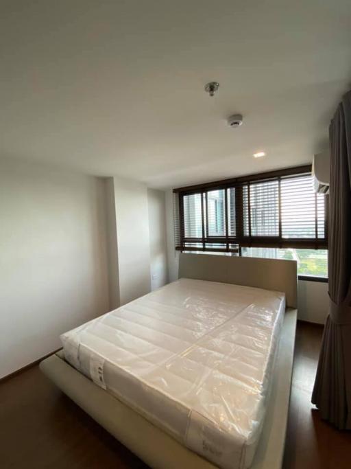 Spacious bedroom with large window and new mattress