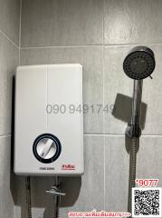 Modern wall-mounted water heater with shower head in bathroom