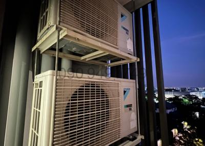 Outdoor view showing air conditioning units on a balcony at twilight