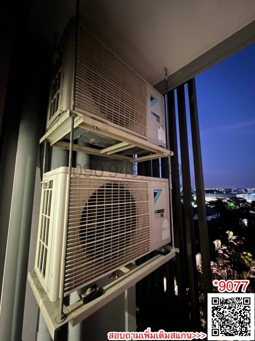 Outdoor view showing air conditioning units on a balcony at twilight