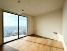 Minimalist bedroom with a large window offering a city view