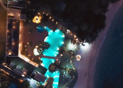 Aerial nighttime view of a residence with a lit pool and surrounding amenities