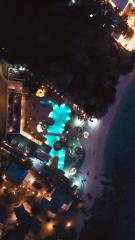 Aerial nighttime view of a residence with a lit pool and surrounding amenities
