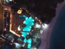 Aerial nighttime view of a residence with a lit pool and surrounding amenities