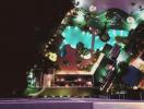 Aerial night view of residential building complex with illuminated pool and garden area