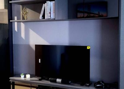 Modern living room interior with wall-mounted shelves, a television, and decorative items