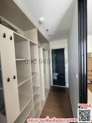 Interior view of a building corridor with built-in shelves leading to a bathroom