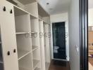 Interior view of a building corridor with built-in shelves leading to a bathroom