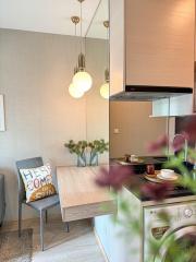 Modern kitchen with dining area, elegant pendant lights, and integrated appliances