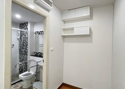 Compact modern bathroom with white and black tiles, wooden floor