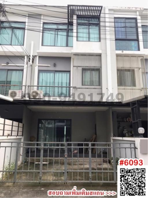 Modern multi-level residential building with balcony and gated entrance