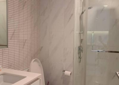 Modern bathroom with glass shower and tiled walls