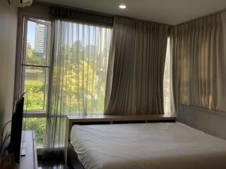 Bright and airy bedroom with large windows and a view of greenery