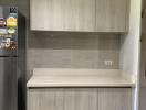 Compact modern kitchen with wooden finish cabinetry and built-in counter