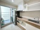 Modern kitchen with stainless steel appliances and balcony access